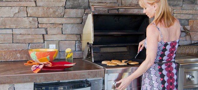 A woman uses a grill.