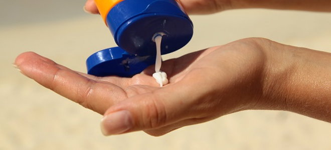 squeezing sunscreen out of a bottle onto a hand