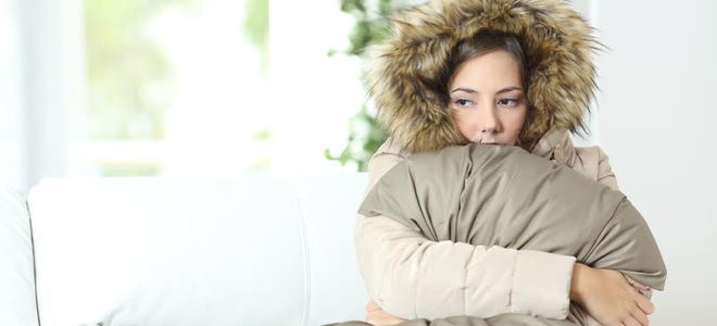 A lady wearing a furry coat holding a blanket. 
