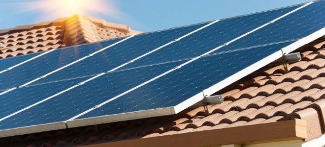 Solar Tiles Vs Panels Doityourself A Section Of Solar Panels On Red Tile Roof Against Blue Sky With