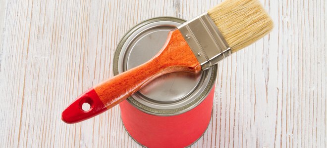 paint brush and can of paint on wood table