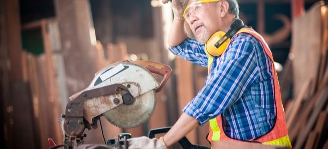 man using circular saw with gloves