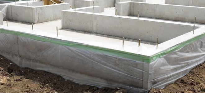 A concrete slab foundation with houses in the background.