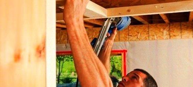 A man working on an unfinished ceiling.