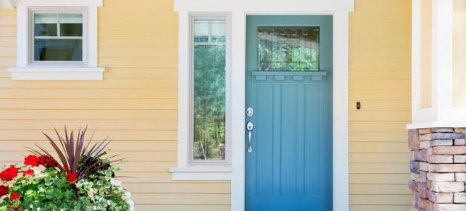 A blue exterior door leading onto a concrete patio.