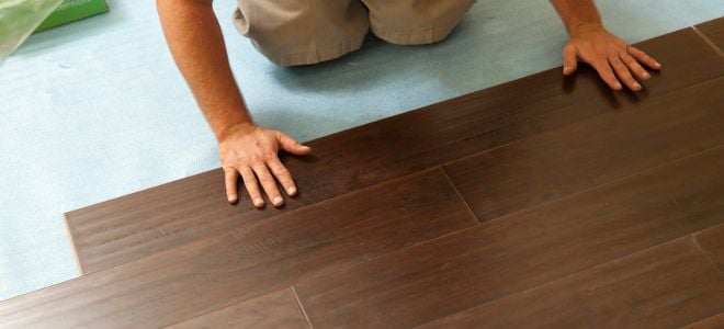 hands installing laminate flooring