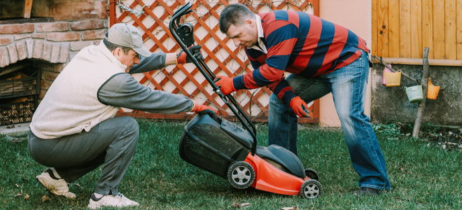 two men working on a lawn mower