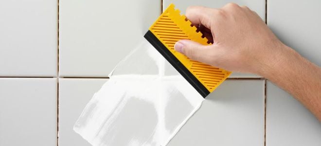 hand scraping grout with plastic tool
