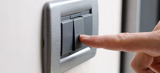 A person pressing a light switch