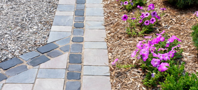 stone walkway in garden with gravel, mulch, and flowers