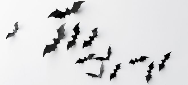 homemade paper bats on a white wall in a natural flock formation
