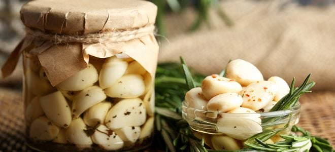 pickled garlic in a glass jar and bowl