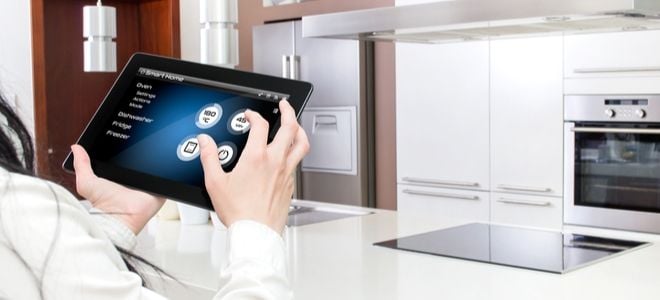 person with iPad adjusting smart appliances