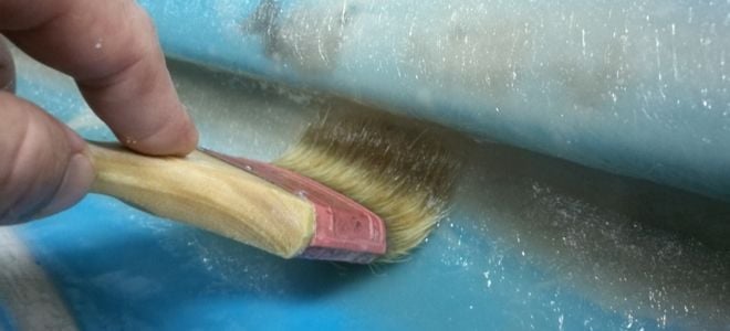 brush painting fiberglass onto a boat hull