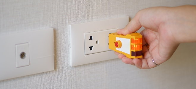 hand checking outlet with small electronic device