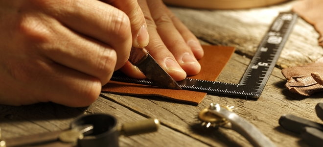 hands measuring and cutting leather