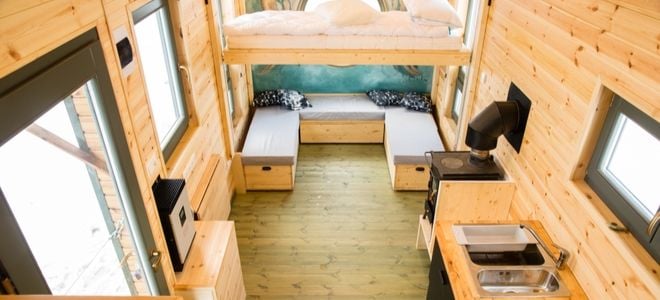 tiny home with wood interior, beds, and kitchen