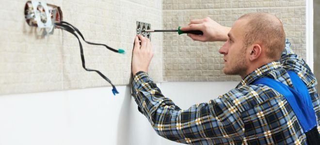 man screwing in wall outlet