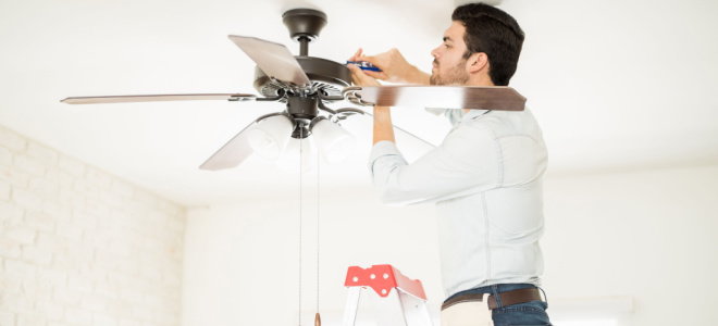 man repairing ceiling fan