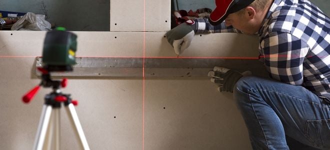 construction worker using a laser measuring tool