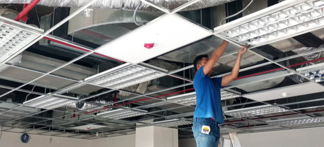 person installing a drop ceiling