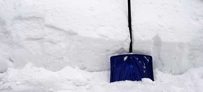 A snow shovel against a snow bank