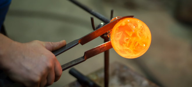 hand crafting glass object with metal tools