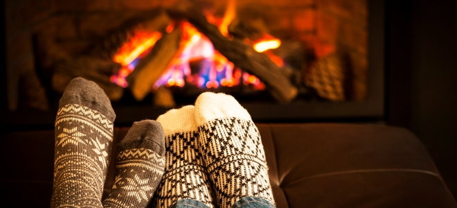 Feet in warm socks warming up by a fire. 