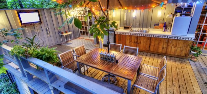 outdoor deck or patio space with bar, table, and shade