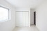 white closet doors and large window in an empty room