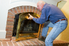 man removing front of a fireplace