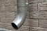 gutter downspout on wall with faux brick paneling