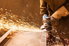 sparks fly as a person with gloves uses an angle grinder