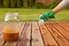 A wood deck with someone applying stain.