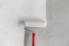 Paint roller applying white paint to wall