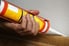 Using a caulking gun, sealant is applied along the edge of a piece of baseboard trim.