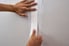 hands applying drywall tape to seal