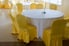 chairs with gold slipcovers around white dining tables