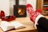 A wood burning oven in the background with Christmas socks and a book in the foreground. 