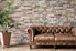leather couch with houseplant and brick wall