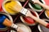 Variety of open paint cans and brushes
