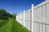 A white vinyl fence next to a newly-mowed yard.