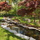 A backyard pond edges with natural stone slabs.