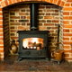 fire burning in wood stove surrounding by brick