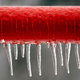 A length of red piping with icicles hanging off of it.