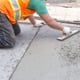 A man works on concrete.