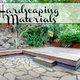 A yard landscaped in wood, stone, and tile with the words, "7 Hardscaping Materials."