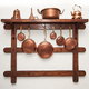 Copper pots and pans hanging from a wooden rack.