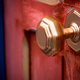 A brass doorknob on a red door.