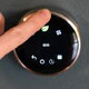 hand touching digital thermostat with leaf and eco icons